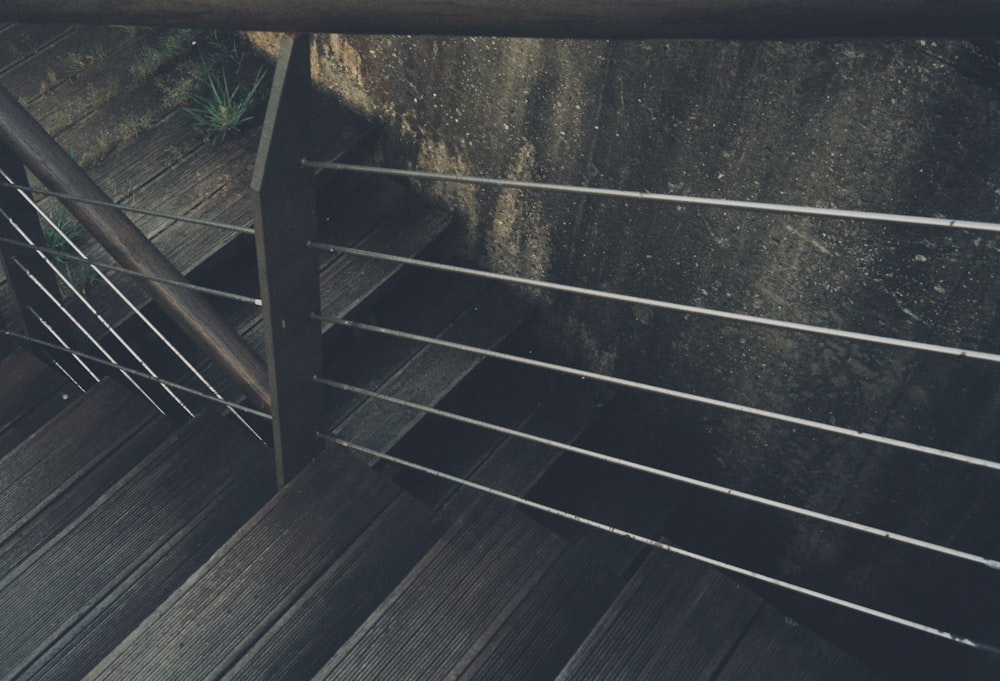 a close up of a metal railing on a wooden deck