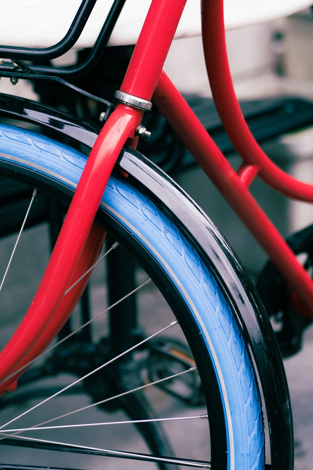 Un primer plano de una bicicleta roja con llantas azules