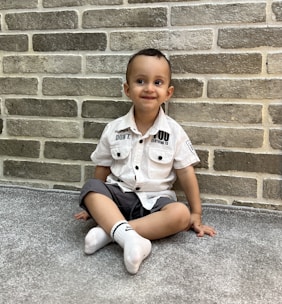 A happy child wearing personalized socks, showing off the embroidered name.