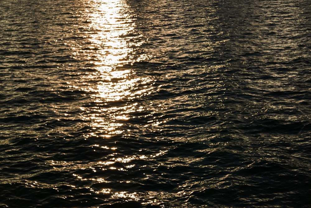 a large body of water with a boat in the distance