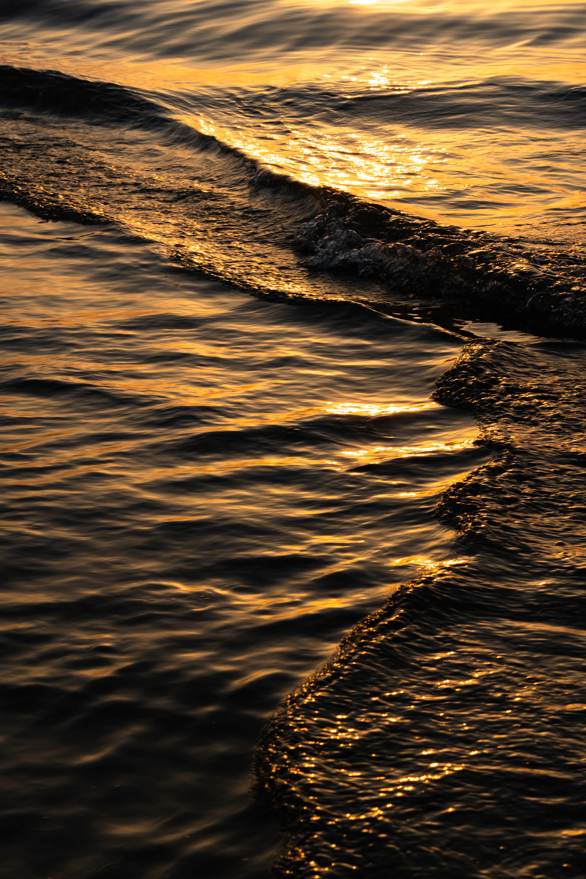 the sun is setting over the ocean waves