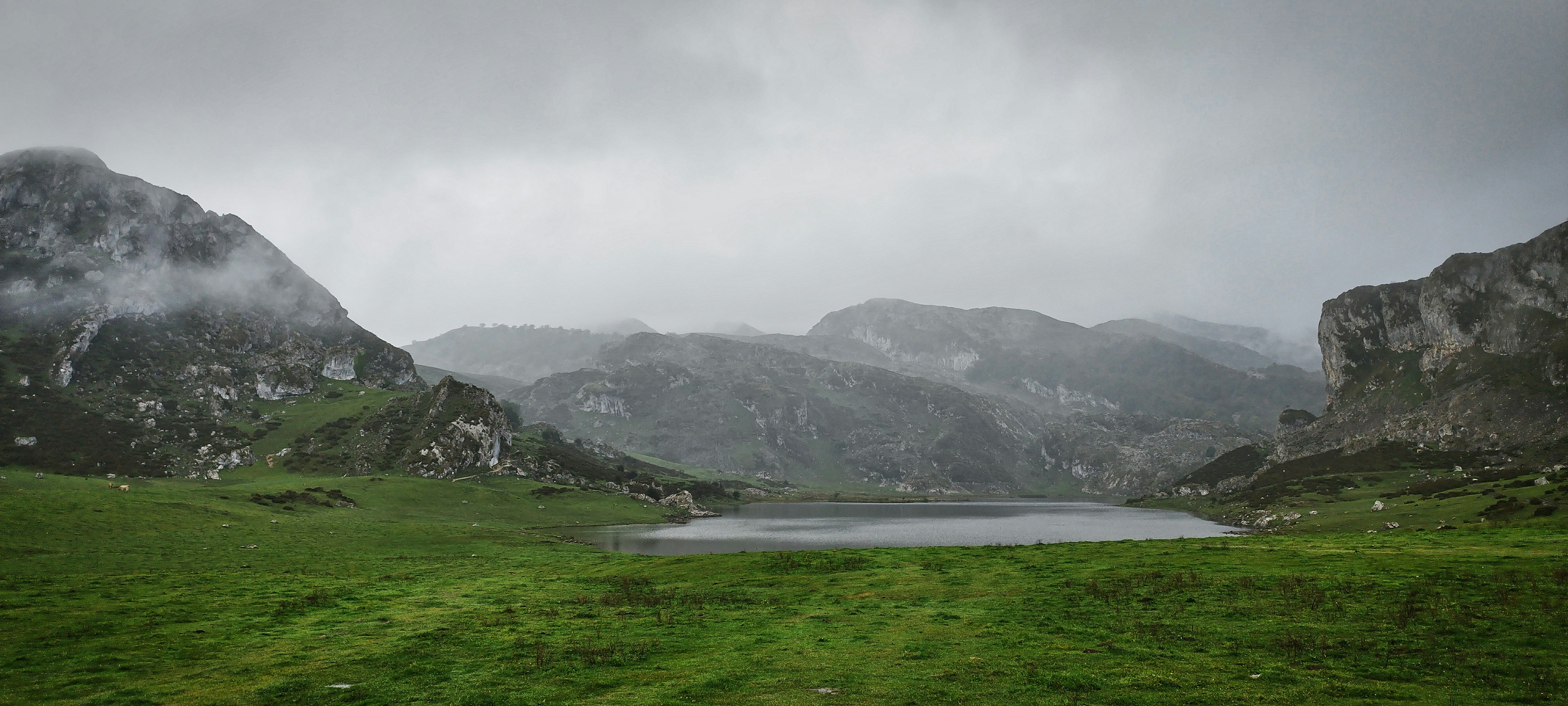 un lac entouré de montagnes par temps nuageux