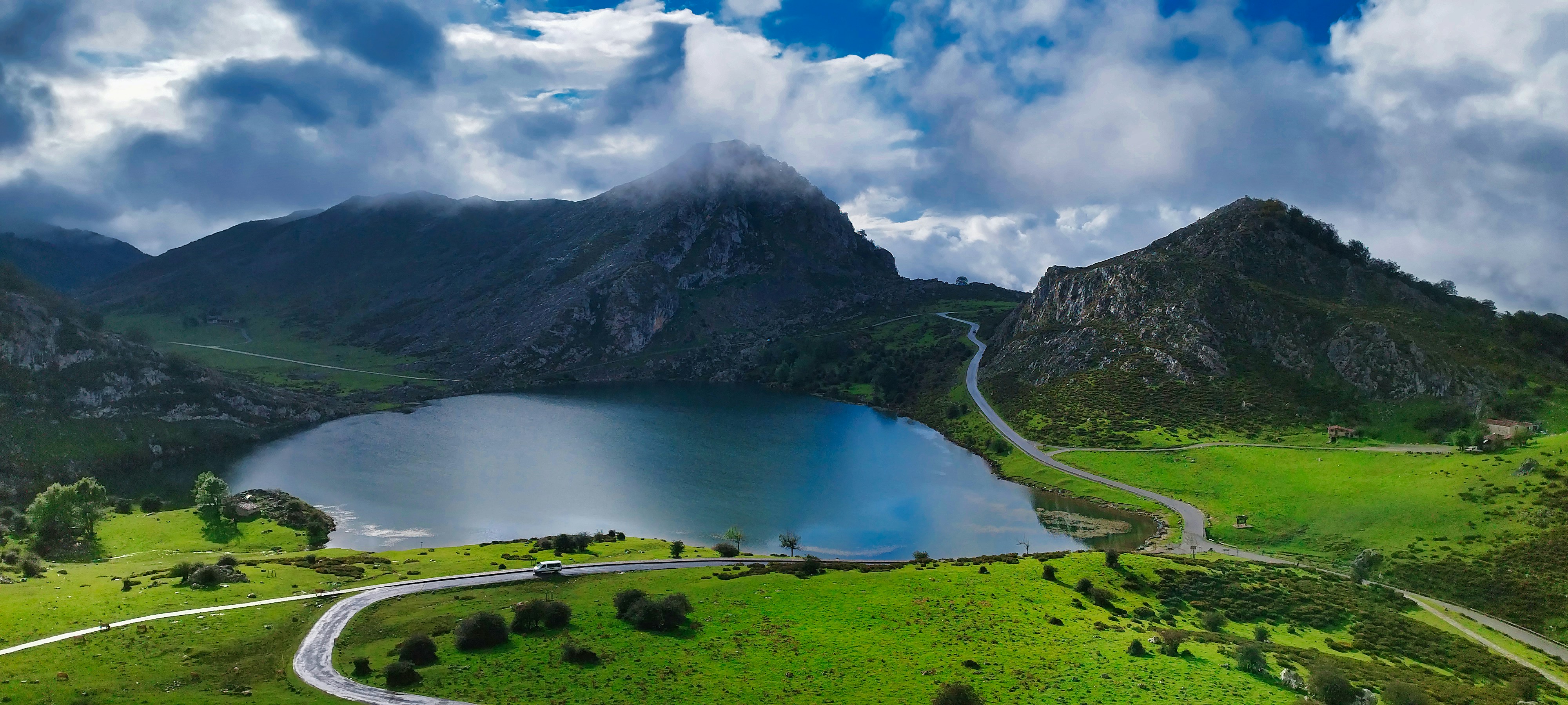 une vue panoramique sur un lac de montagne et une route sinueuse