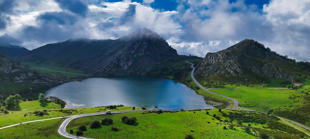 a scenic view of a mountain lake and a winding road