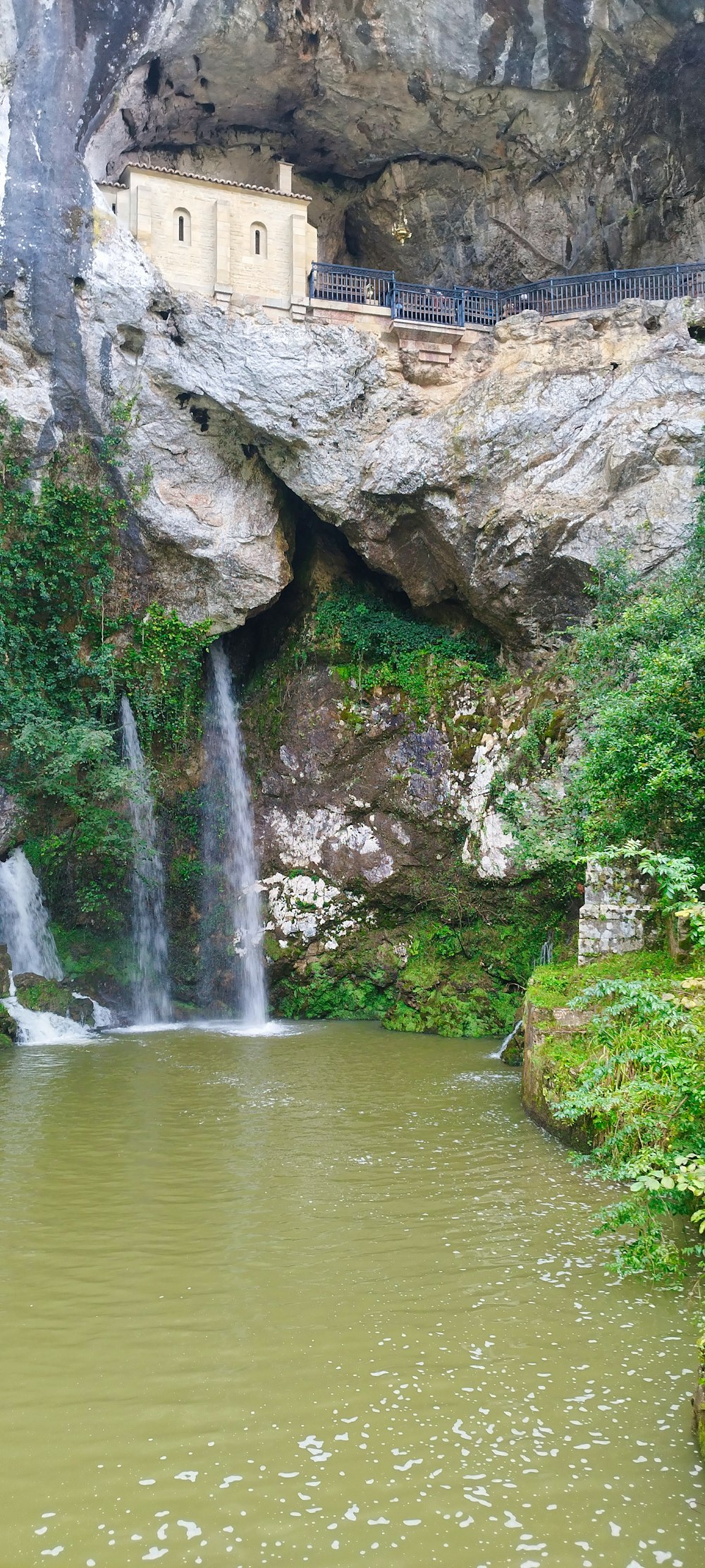 a small waterfall in the middle of a body of water