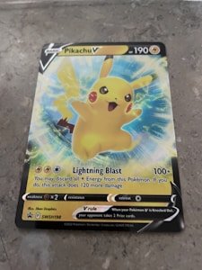 A Pokémon trading card featuring Pikachu V with 190 HP. The card displays an illustration of Pikachu with an energetic pose surrounded by blue and yellow electric sparks. The card includes details about its attack, 'Lightning Blast,' which does 100+ damage. Weakness, resistance, and retreat cost icons are shown at the bottom.