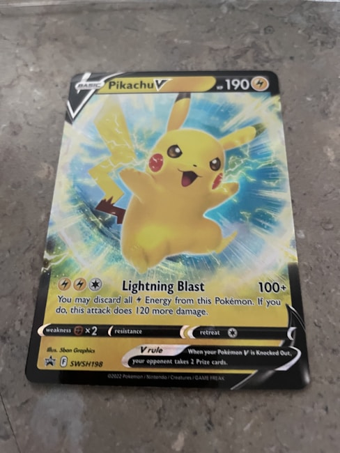 A Pokémon trading card featuring Pikachu V with 190 HP. The card displays an illustration of Pikachu with an energetic pose surrounded by blue and yellow electric sparks. The card includes details about its attack, 'Lightning Blast,' which does 100+ damage. Weakness, resistance, and retreat cost icons are shown at the bottom.