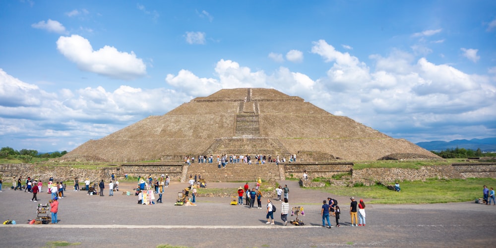 a group of people standing in front of a pyramid