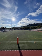 Young people practicing sports on a sunny field surrounded by mountains.