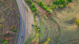 Aerial view of a flat, open land parcel near a quiet country road.