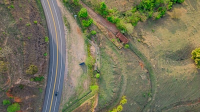 An aerial shot of a flat land parcel bordered by a quiet country road.
