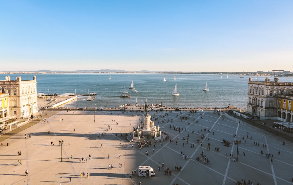 an aerial view of a city square with a body of water in the background