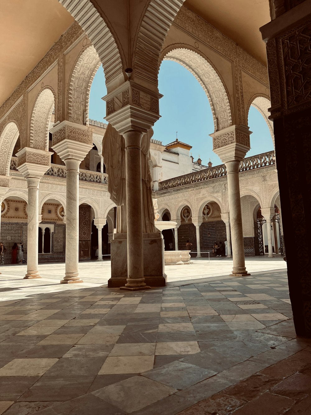 a large building with arches and a clock tower in the background