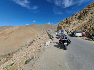 Drivers and guests sharing stories and laughter during a scenic stop, surrounded by rolling hills.