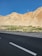 Photo of a completed asphalt road with clear markings and mountains in the background.