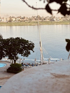 The Libertas docked at a quiet riverside, with surrounding greenery and soft sunlight