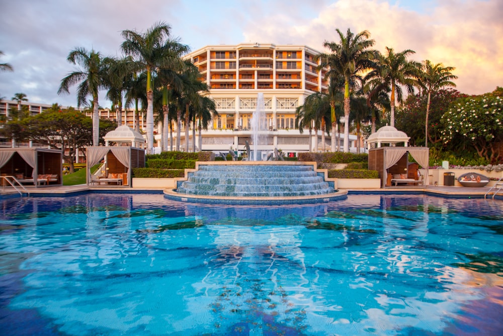 a hotel with a fountain in front of it