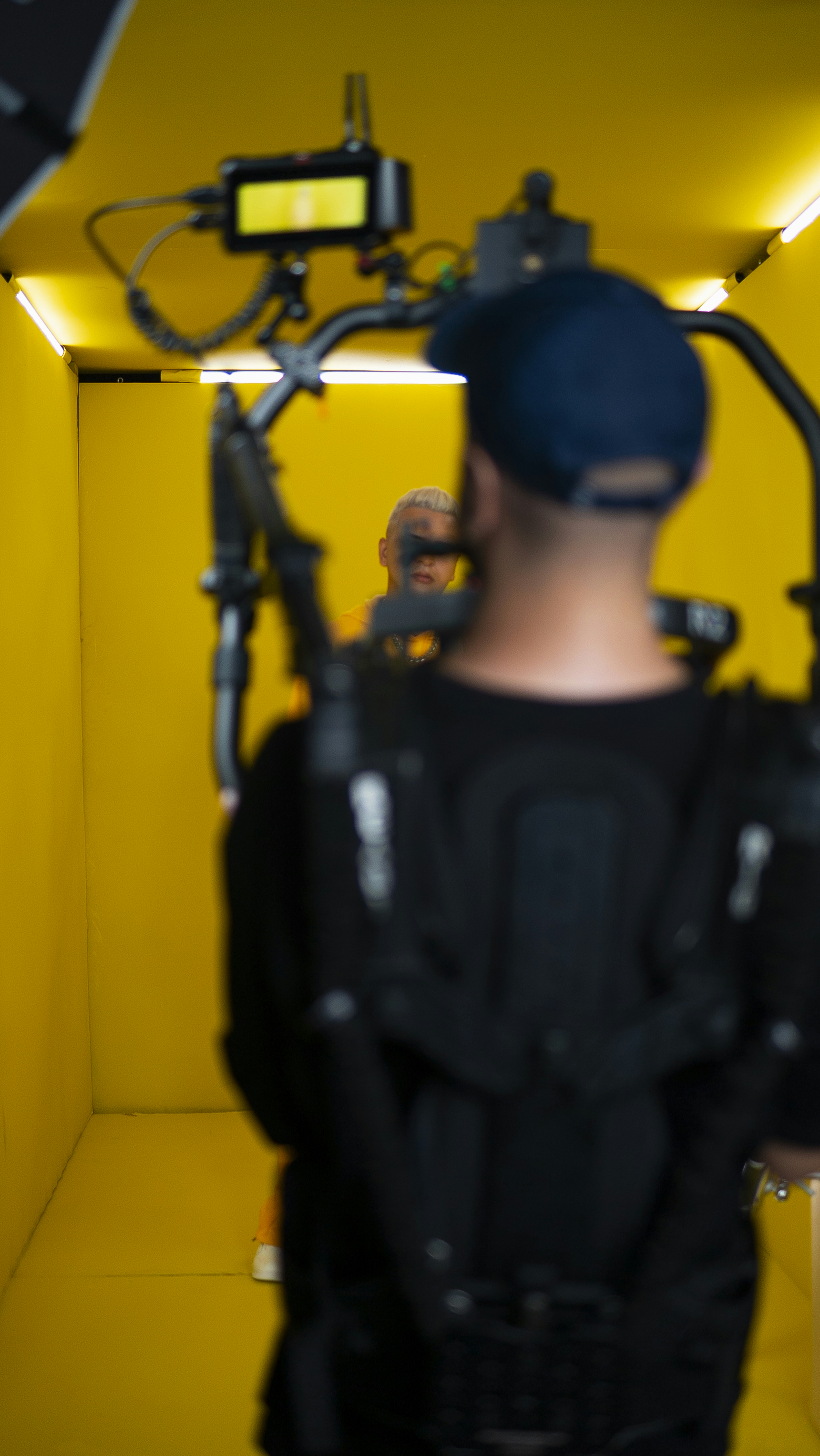 a man standing in a yellow room with a camera