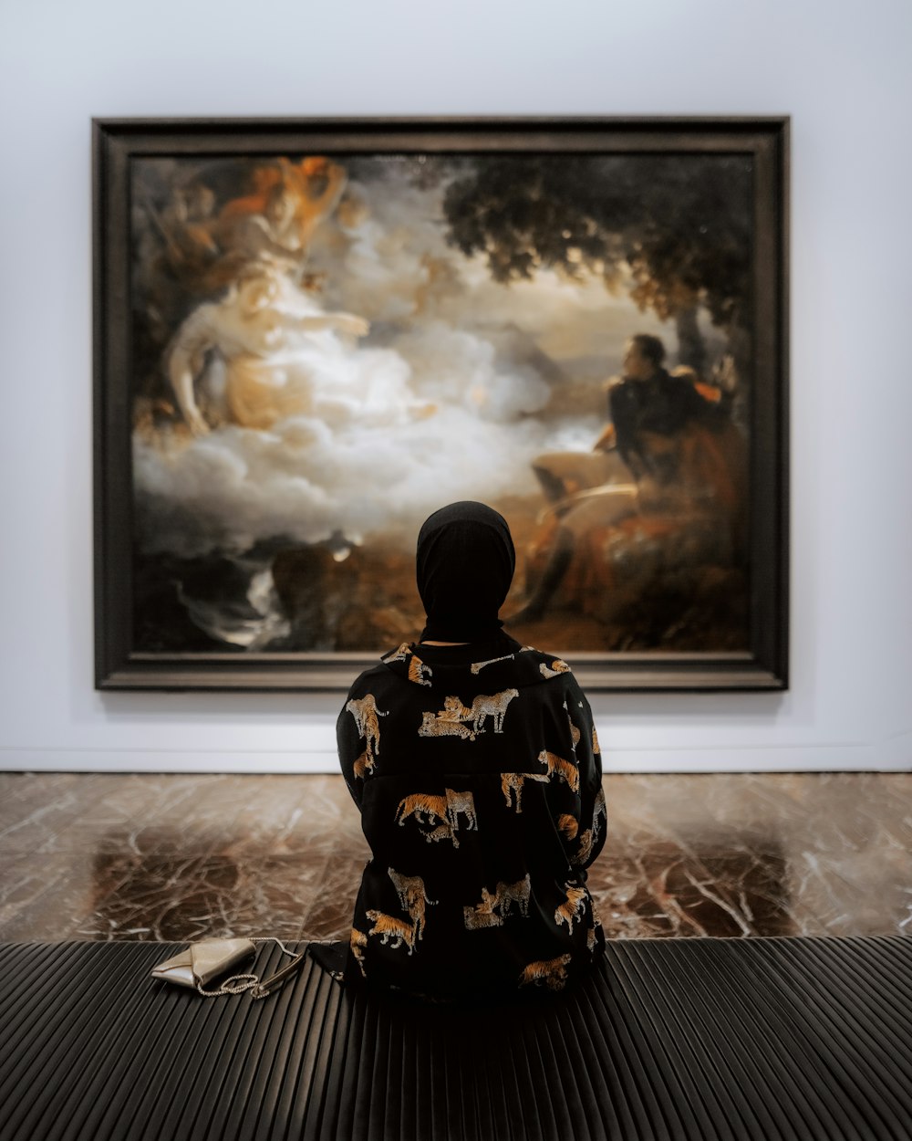 a person sitting in front of a painting