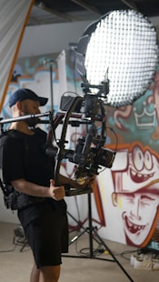 a man standing in front of a camera holding a light