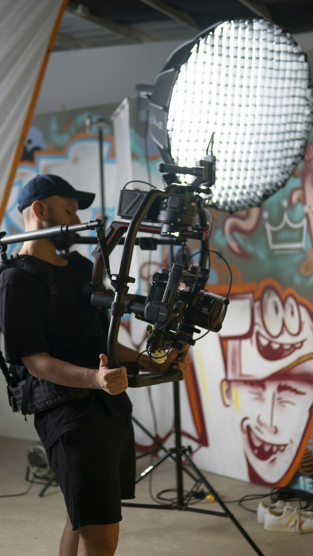 a man standing in front of a camera holding a light