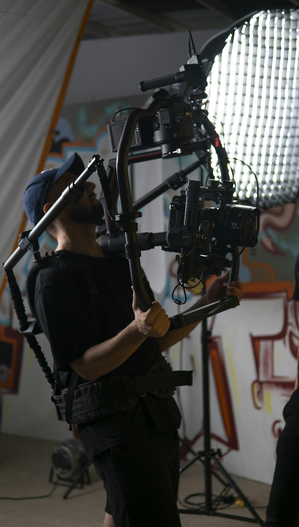 Un hombre sosteniendo una cámara frente a una cámara
