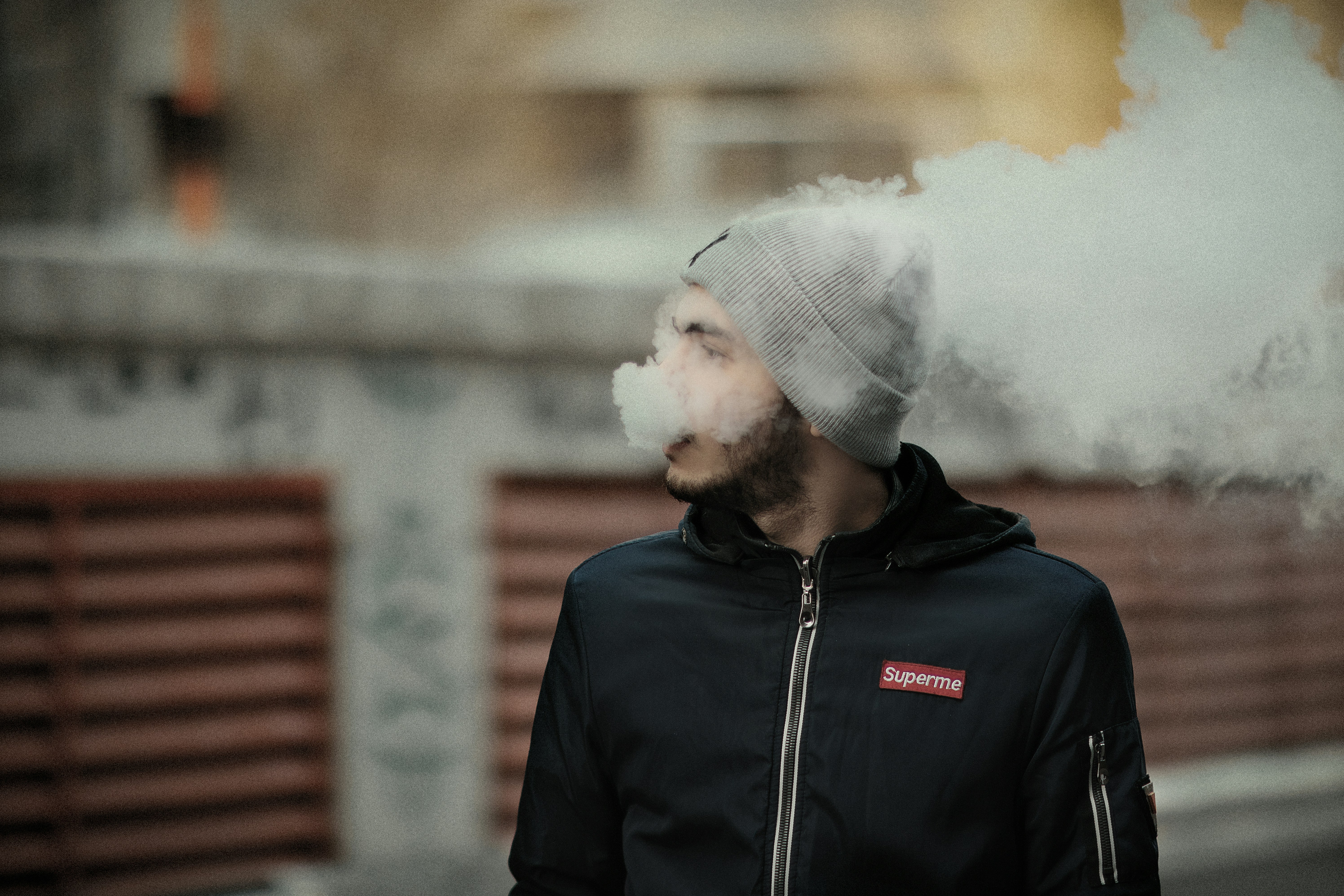 A man wearing a beanie smoking a cigarette photo – Free Man Image on  Unsplash