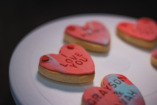 A collection of heart-shaped biscuits with various custom messages, perfect for gifts.