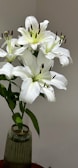 Elegant white lilies arranged in a rustic ceramic vase