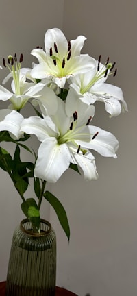 Elegant white lilies arranged in a rustic ceramic vase