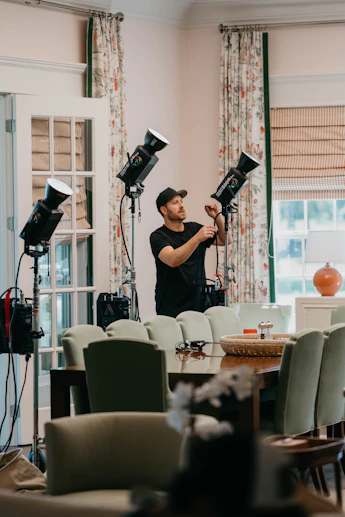 Technician carefully adjusting lighting setup in a modern conference room