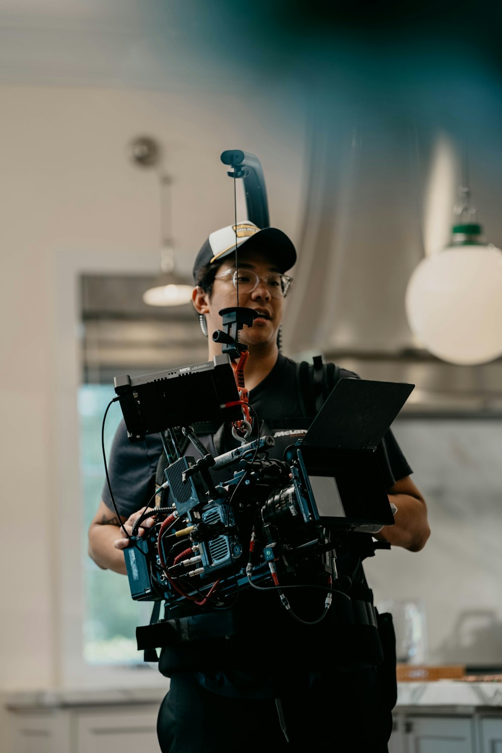 a man holding a camera in a kitchen