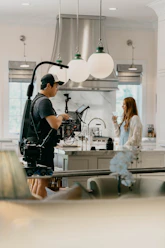 A dynamic photo of a content creator filming a lifestyle video in a bright London apartment.