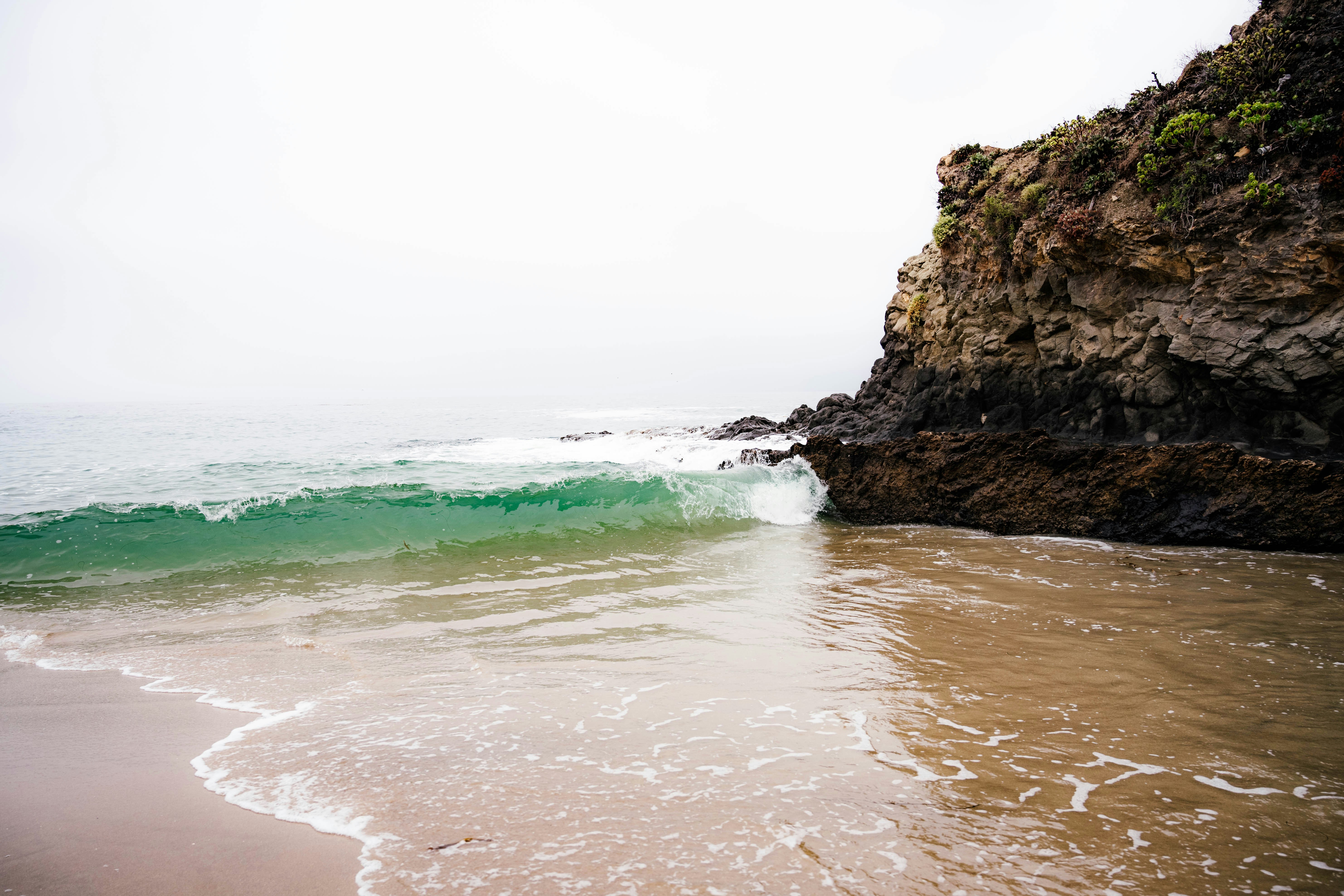 a body of water sitting next to a rocky cliff