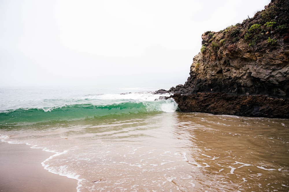 a body of water sitting next to a rocky cliff