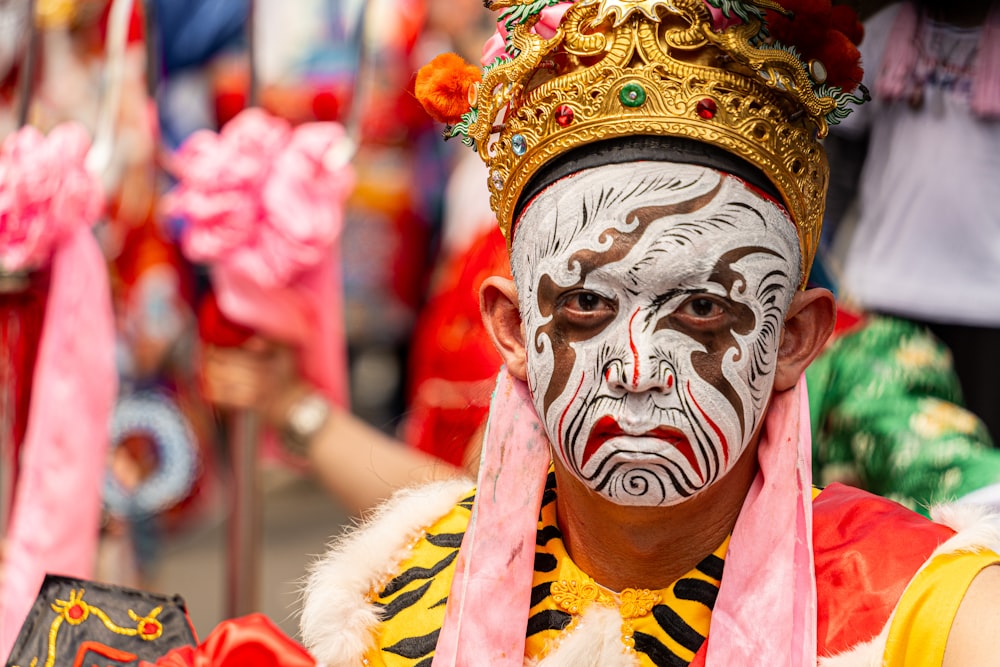 a man with face paint and a crown on his head