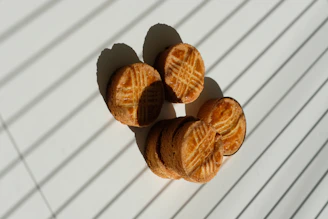 A stack of golden oatmeal raisin cookies on a rustic wooden table.