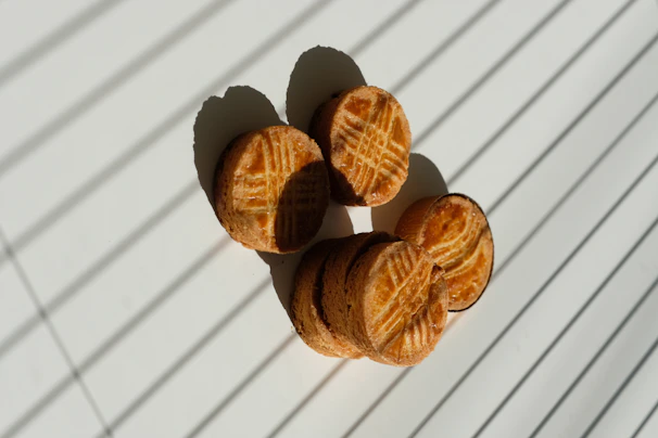 Close-up of golden-brown cookies stacked on a rustic wooden board.