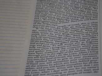 A close-up view of a page from a book with printed text. The text includes paragraphs and has references to 'Sovereign LORD' and 'Israel'. On the left edge, there are perforations suggesting it might be a detachable page or part of a binder. The part of the page in focus appears to be from a religious or theological text, possibly from a Bible.