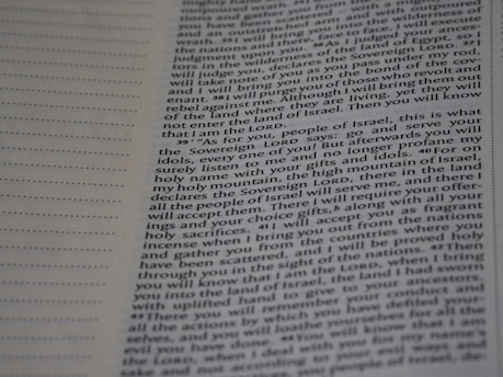 A close-up view of a page from a book with printed text. The text includes paragraphs and has references to 'Sovereign LORD' and 'Israel'. On the left edge, there are perforations suggesting it might be a detachable page or part of a binder. The part of the page in focus appears to be from a religious or theological text, possibly from a Bible.