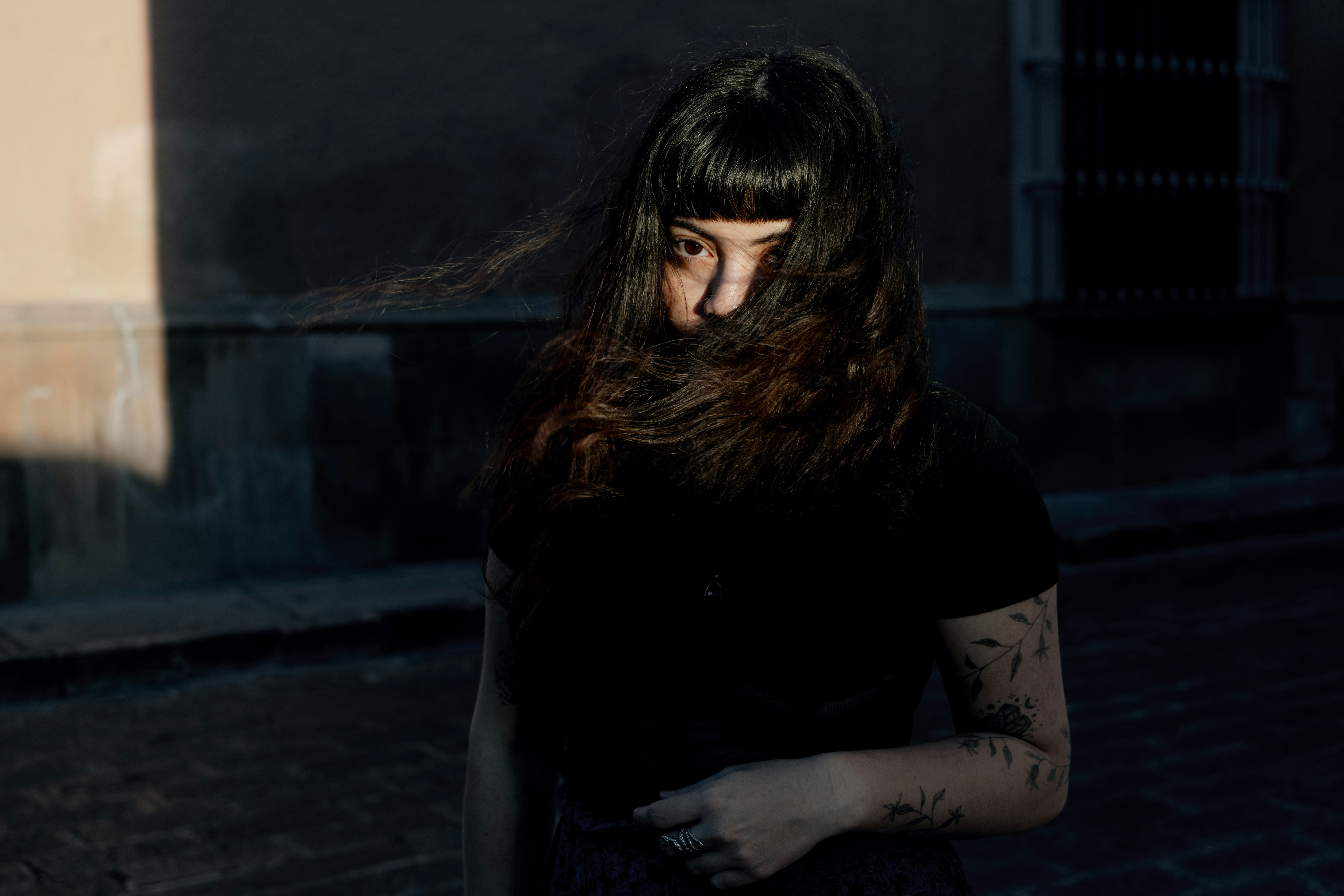 a woman with long hair standing on a street