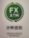 A green and white logo featuring the text 'FX ATM' at the center of a globe with arrows encircling it. Below the logo is text in both Japanese and English that reads 'Foreign Currency Withdrawal'.