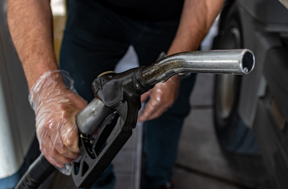 a man pumping gas into a car at a gas station