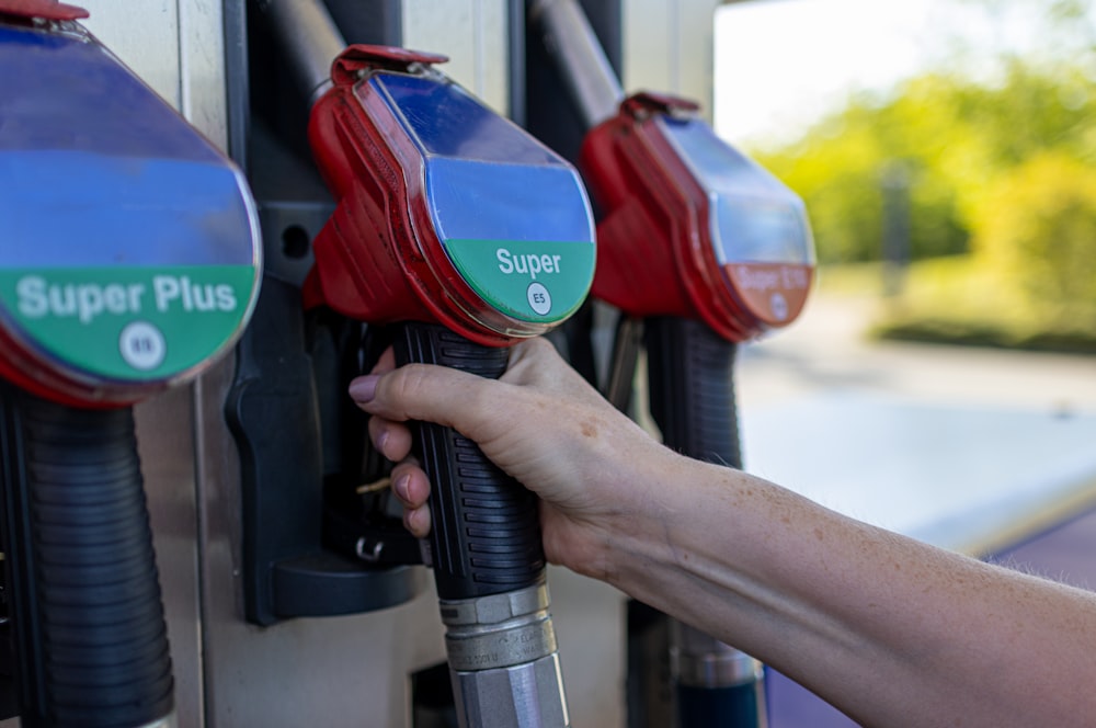 a person's hand is holding a gas pump