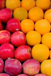 a pile of oranges and apples sitting next to each other