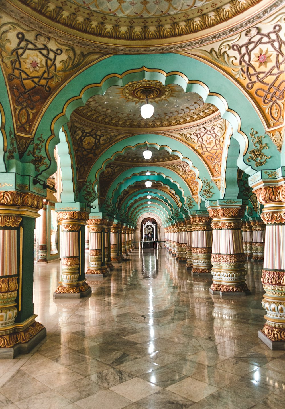 a long hallway with columns and a clock on the wall