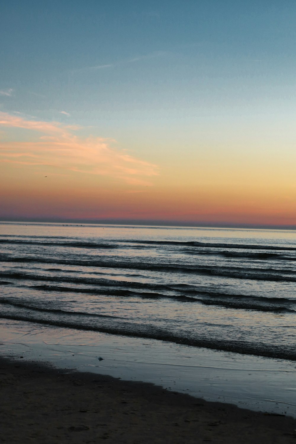 a person walking on the beach with a surfboard