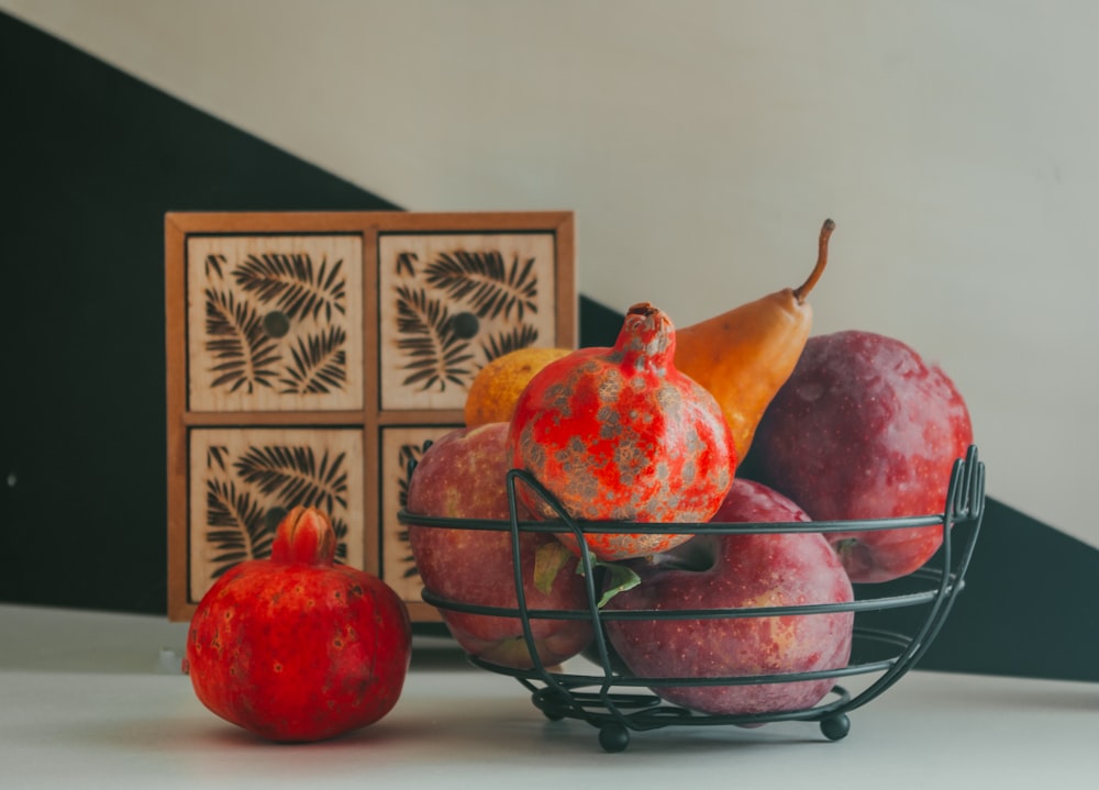 a bowl of pomegranates and a box of oranges