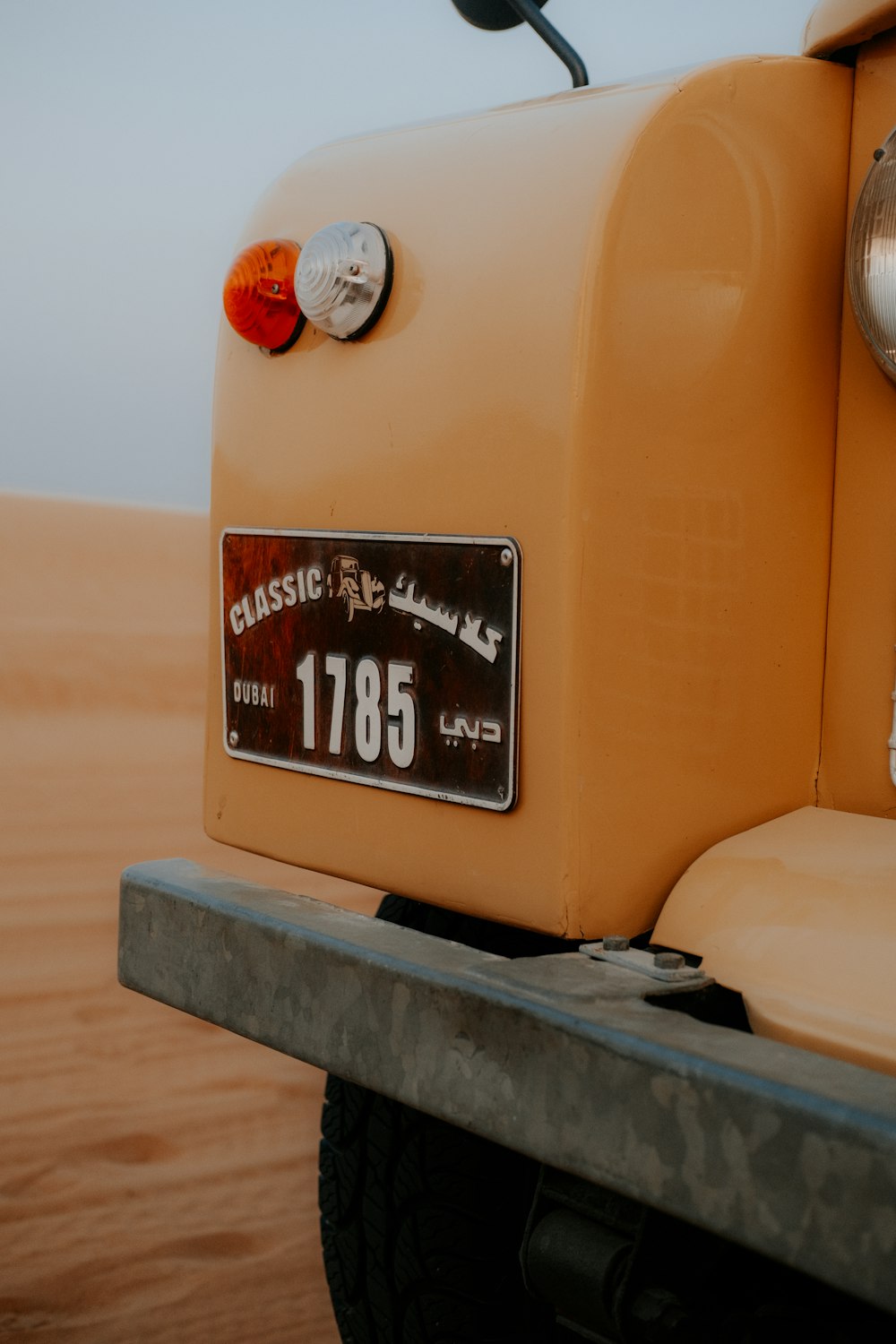 a close up of a yellow truck with a license plate