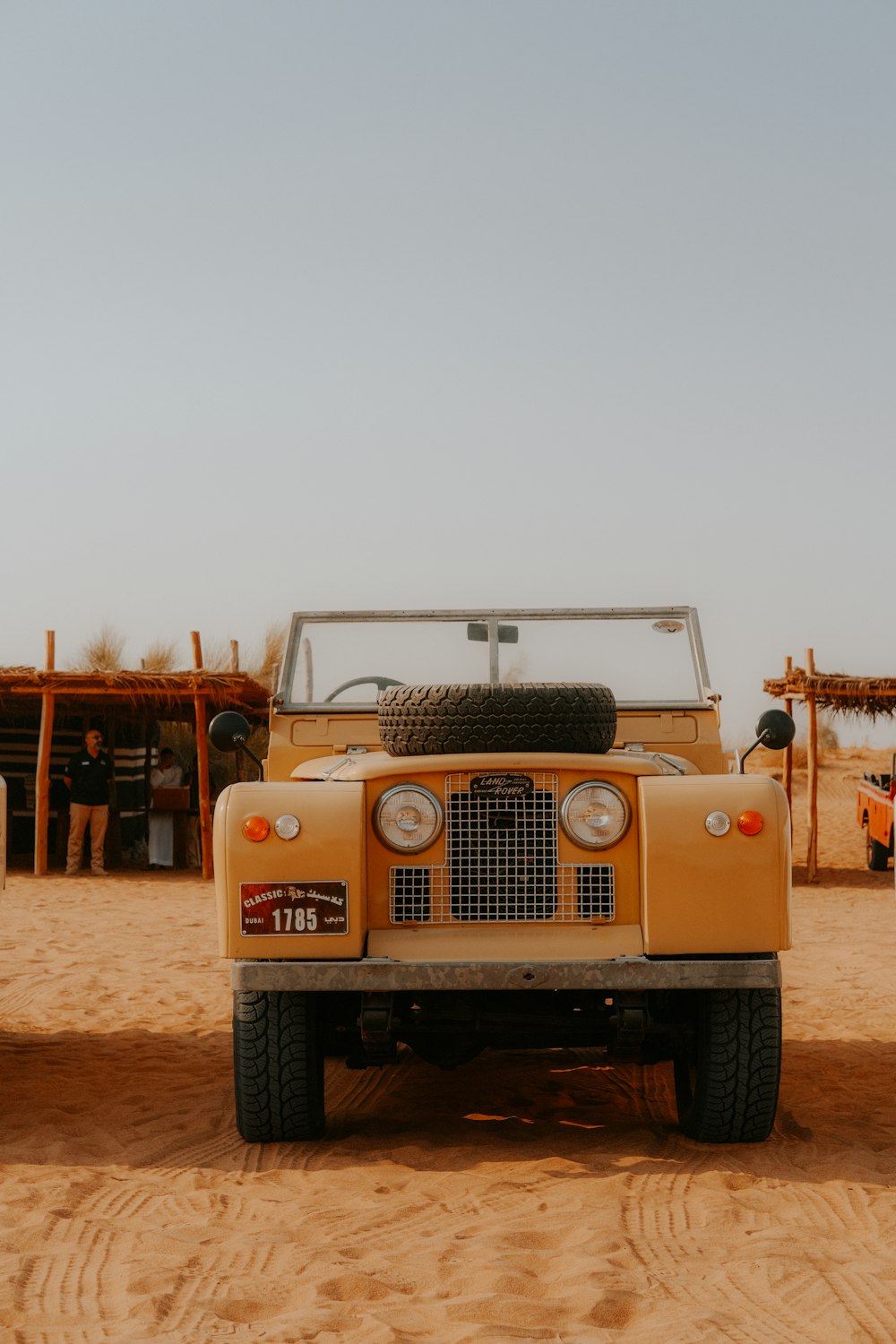 a yellow jeep parked in the middle of the desert